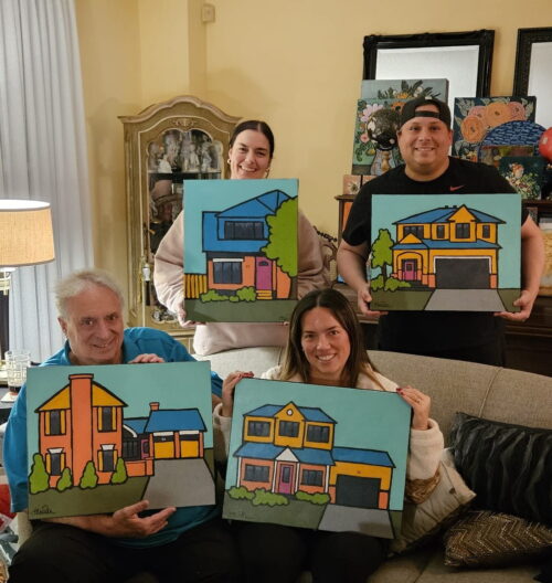 Family holding their custom house paintings