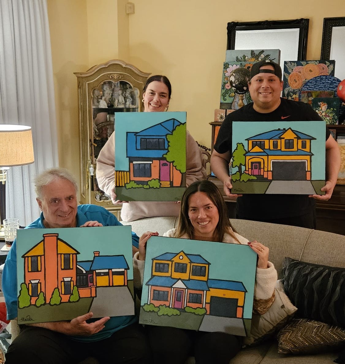 Family holding their custom house paintings